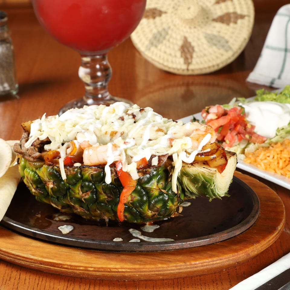 La Fuente's pineapple fajita with steak, shrimp, peppers, and melted cheese, served with rice and salsa.
